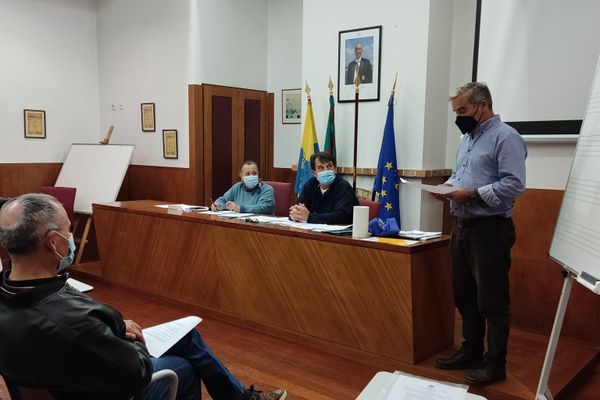 pessoa a ler papel em frente a uma audiência