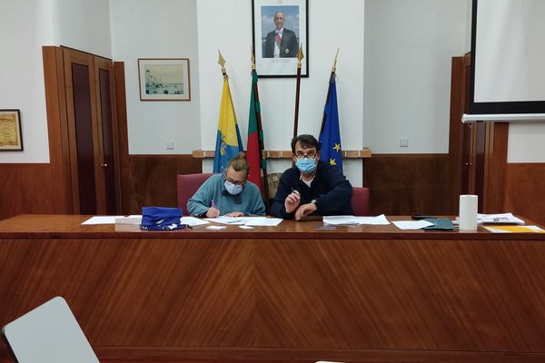 duas pessoas com papeis em cima duma mesa